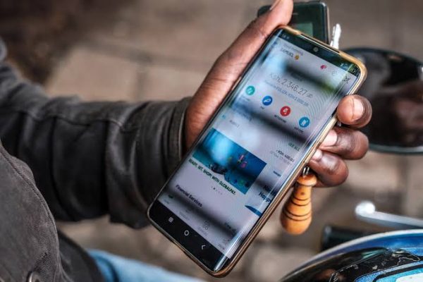A person using a smartphone on a Mobile money app. Photo/Screengrab by Ronny TV