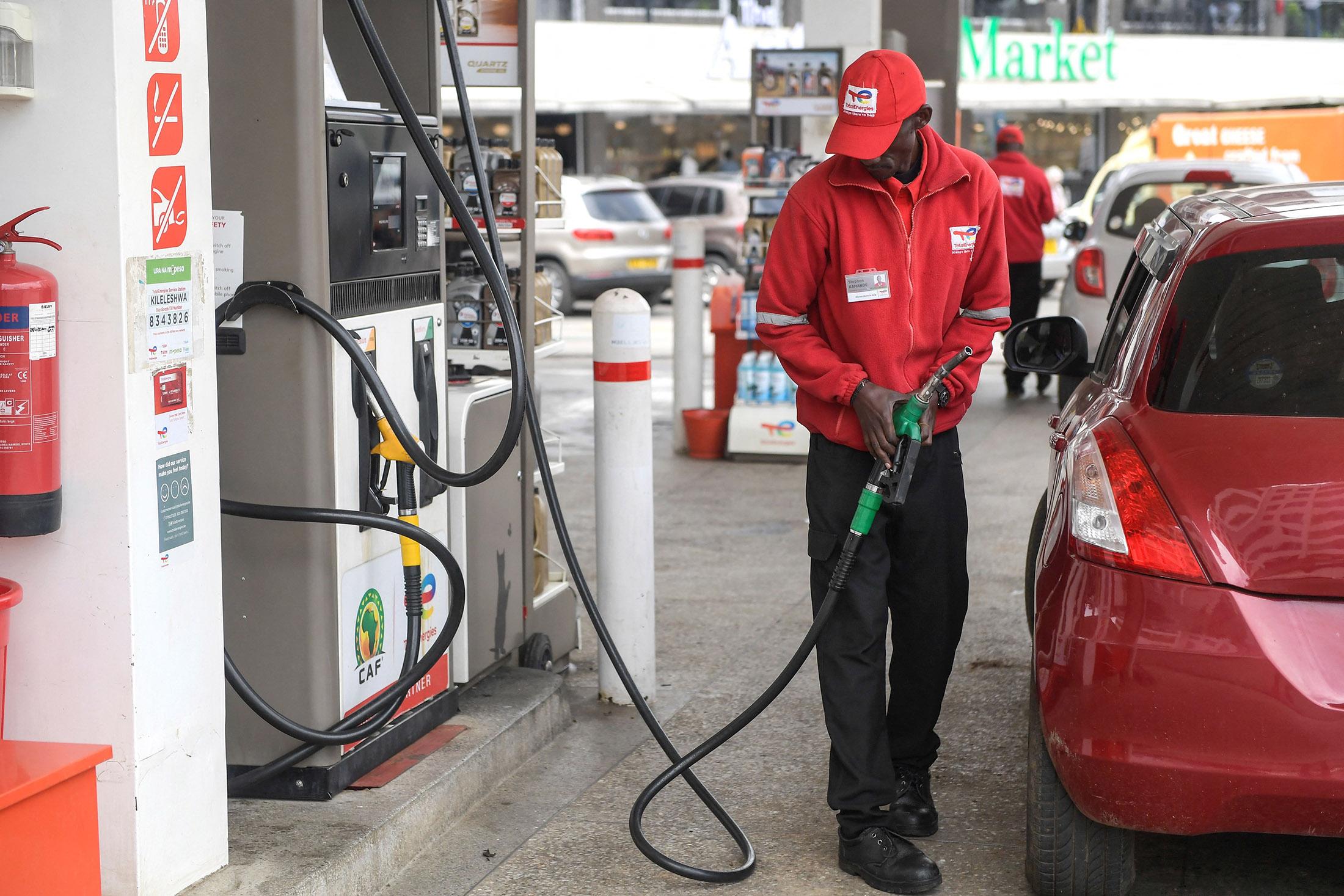 A Petrol station attendant is filling a car