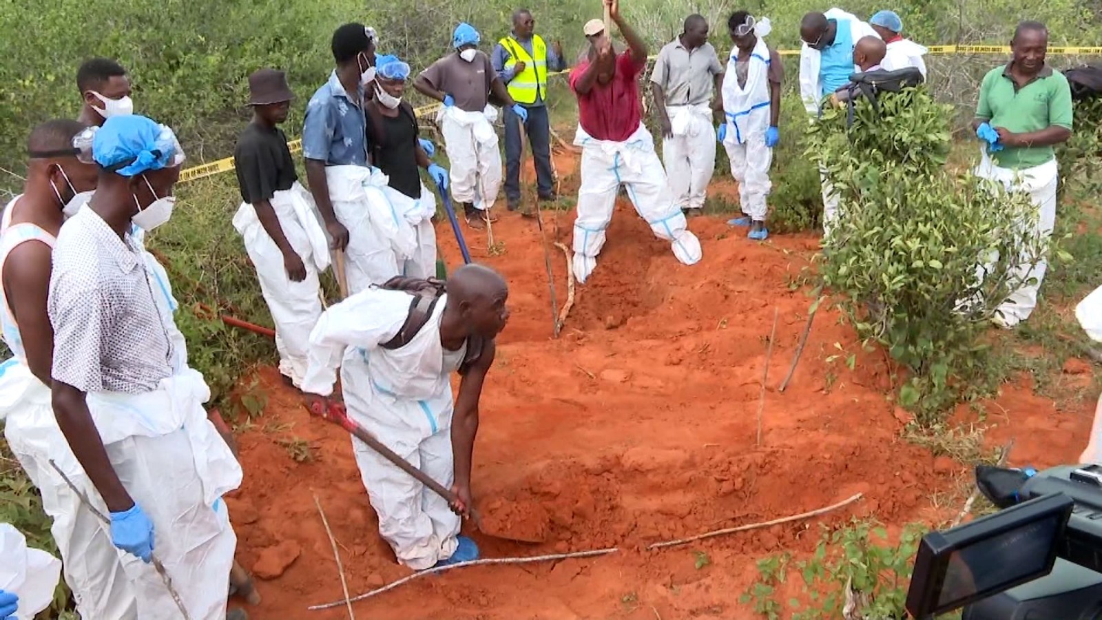 Workers in protective gear dig mass graves in Kenya's Shakahola Forest, site of the 2023 starvation cult massacre.